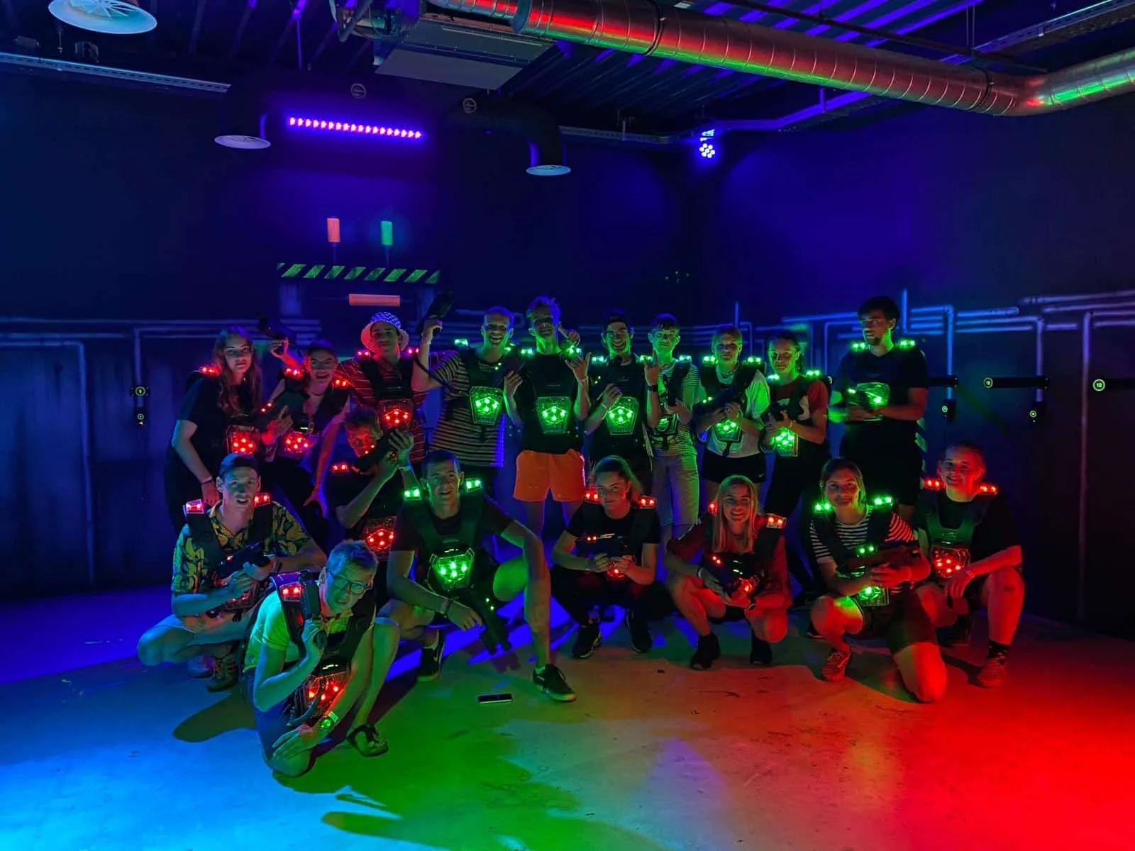 Groep scouts in neonkleuren onder blacklight tijdens een feestavond