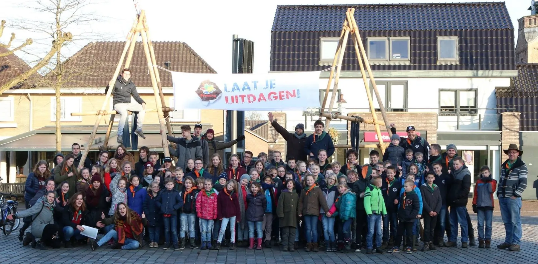 Grote groepsfoto van alle leden en leiding van Scouting Nunspeet op straat